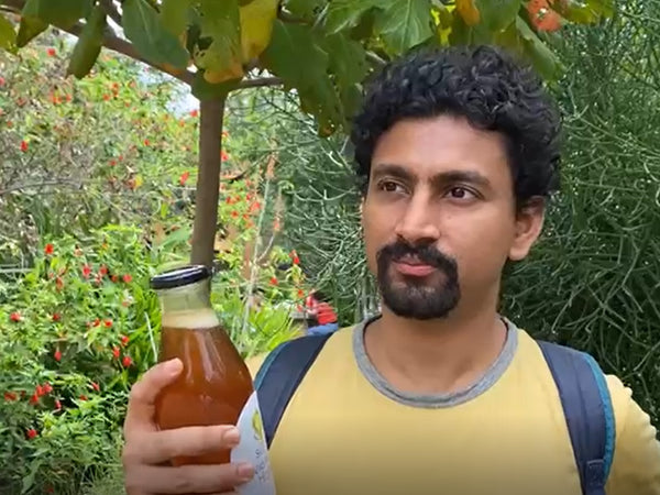 A customer with a bottle of Svastya Organic Farms wild forest honey